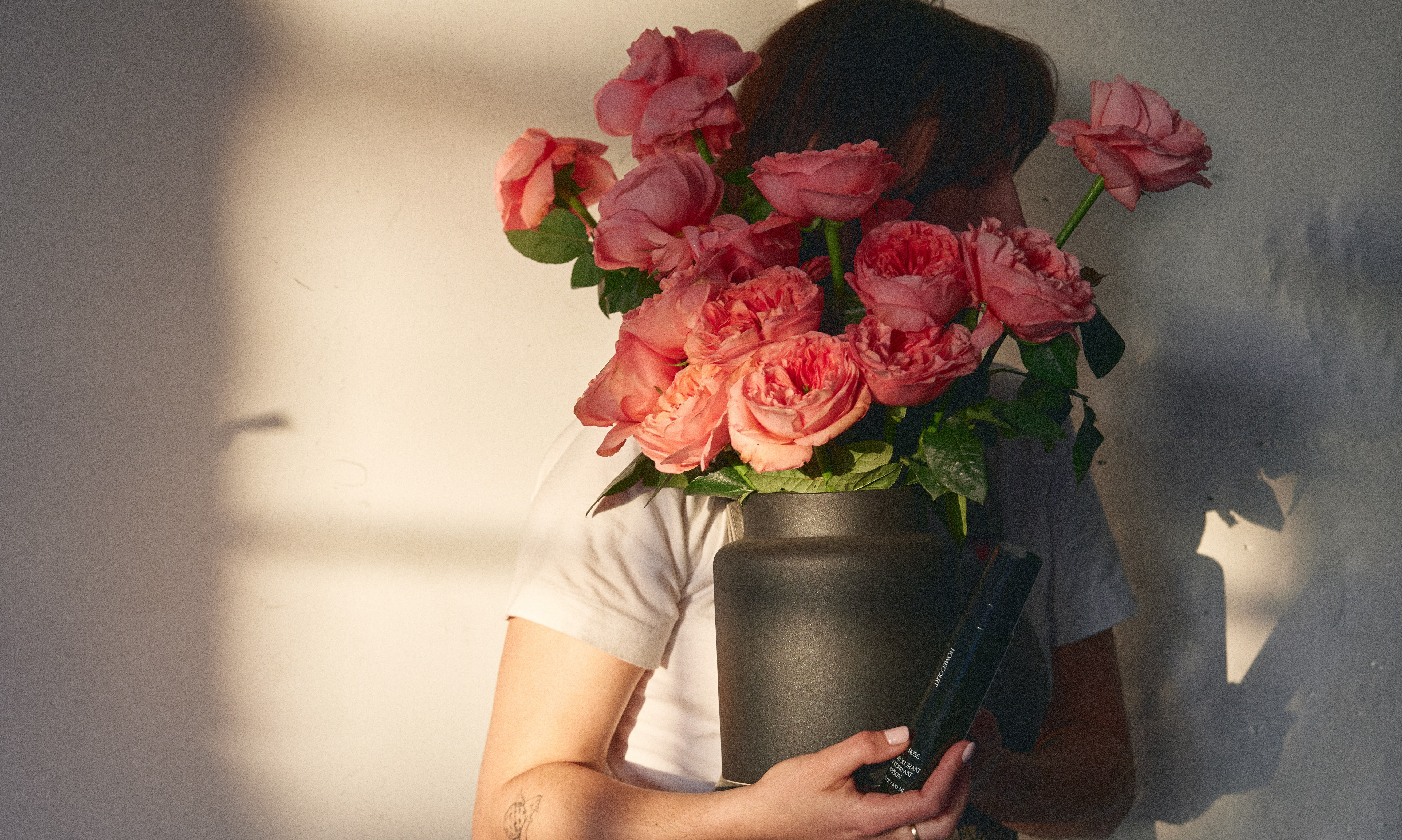 Woman holding a bouquet of roses in a vase